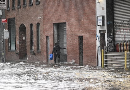 Una viandante caminaba el viernes por una calle afectada por las lluvias en la zona de Brooklyn.