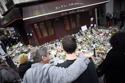 Un grupo de personas se concentran en las puertas del café Le Carillon durante el minuto de silencio celebrado en París (Francia).