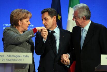 Sarkozy besa la mano de Merkel en presencia de Monti, ayer en Estrasburgo.