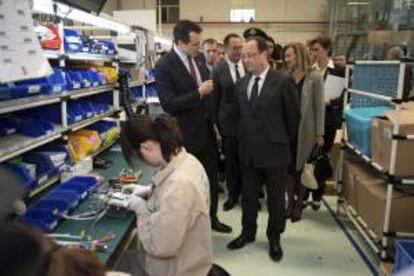 El presidente francés François Hollande (d), durante su visita al taller de la empresa gala Bernard Controls, en Pekín, China, hoy, jueves 25 de abril de 2013.