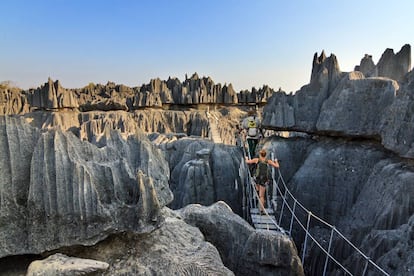 Una pareja de turistas cruza un puente colgante en la reserva de Tsingy de Bemaraha, en Madagascar.