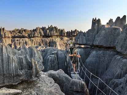 Una pareja de turistas cruza un puente colgante en la reserva de Tsingy de Bemaraha, en Madagascar.