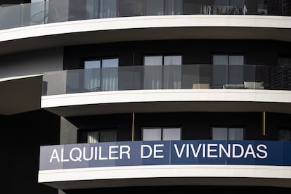 Edificio de pisos en alquiler con un cartel publicitario en la Avenida Carrilet de Barcelona.