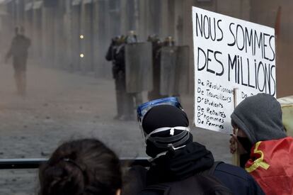 Un manifestante sostiene un cartel de lectura "Somos millones" mientras evitan a la policía antidisturbios en Rennes, Francia.