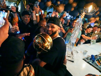 Jamal Murray se abraza al trofeo tras ganar la NBA con Denver Nuggets.