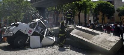 Workers try to remove a collapsed bridge from a bus in Guerrero state.