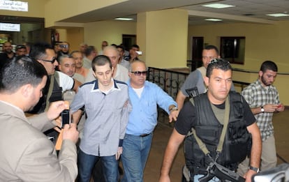 Gilad Shalit, escoltado por mediadores egipcios y miembros de Hamas, es conducido hacia el paso de Rafah.