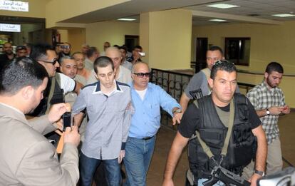 Gilad Shalit, escoltado por mediadores egipcios y miembros de Hamas, es conducido hacia el paso de Rafah.