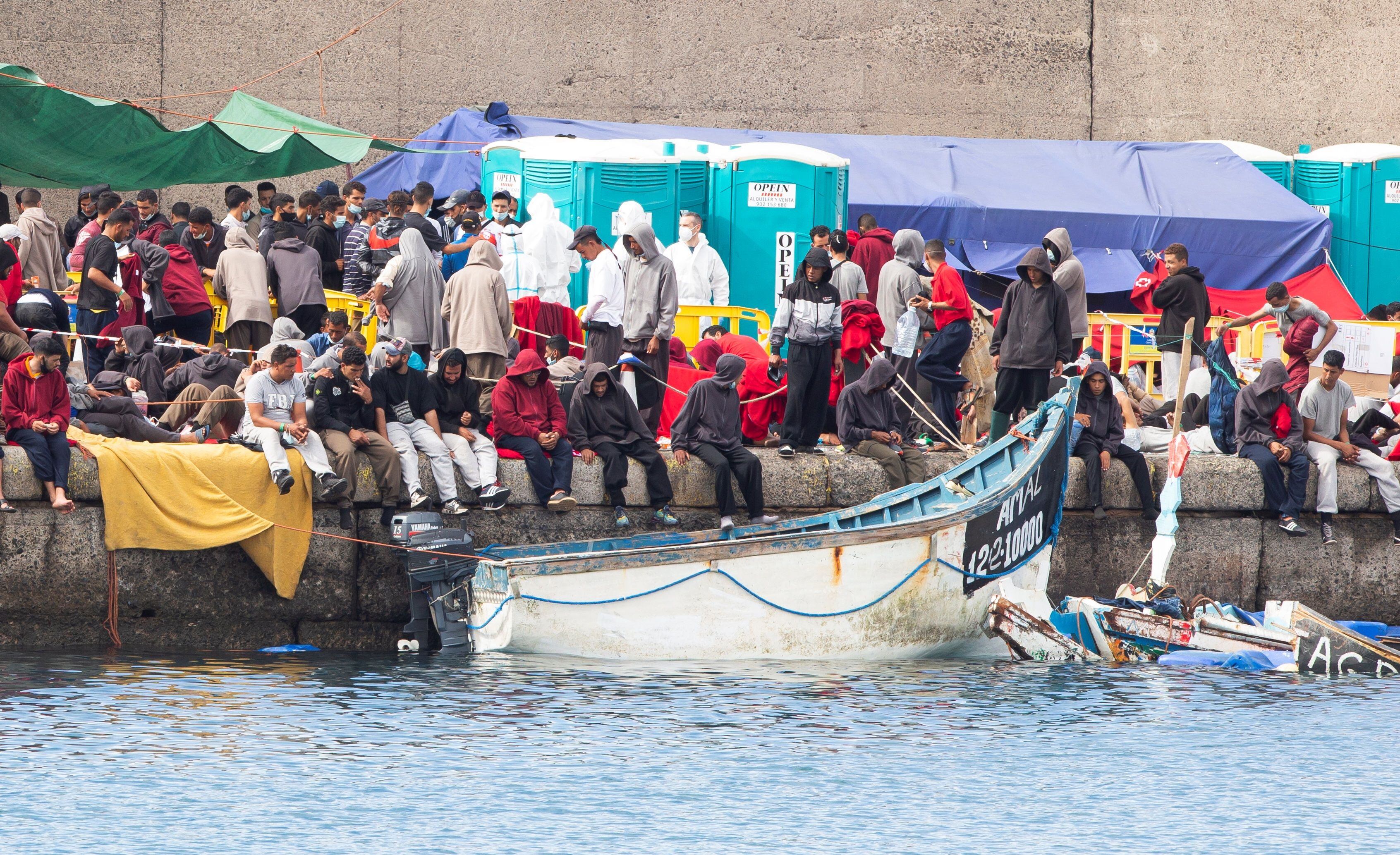 Grupos de inmigrantes abarrotan el muelle de Arguineguín, desmantelado este lunes.