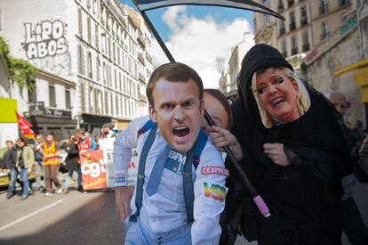 Dos manifestantes con máscaras de los candidatos franceses a la presidencia, Emmanuel Macron (i) y Marine Le Pen (d) participan en la marcha de los trabajadores en Marsella, al sur de Francia.