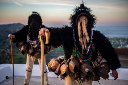 Dos hombres vestidos con el tradicional disfraz de 'anciano', ataviados con capas negras peludas y máscaras de cuero de cabra, participan en el Carnaval de Skyrian, en la isla de Skyros, al noreste de Atenas.