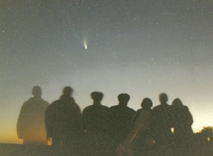 Un grupo de aficionados a la astronomía se fotografía con el cometa <i>Hale-Bopp</i>.