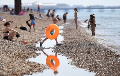 Un niño salta un charco en la playa de Brighton. Reino Unido se prepara para el día más caluroso del año con temperaturas cercanas a los 36 grados mientras la ola de calor persiste en todo el país.