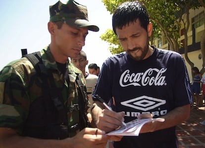 Pedro Reyes, de la selección chilena, le firma un autógrafo a un soldado al terminar un entrenamiento, durante la Copa América en Barranquilla, (Colombia) el viernes 13 de julio de 2001. 