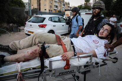 Fuerzas de seguridad israelíes trasladan a un judío herido por disparos en las protestas del jueves en la ciudad de Lod.