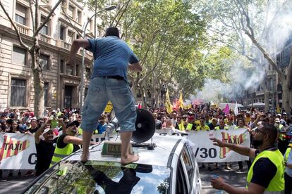Un taxiste encima de un taxi frente al pelotón de la manifestación que recorre las calles de Barcelona.