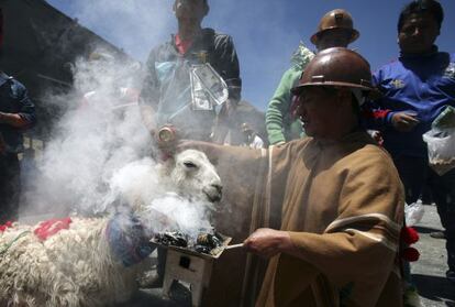 Un minero sujeta a una llama durante un ritual carnavalesco en Oruro.