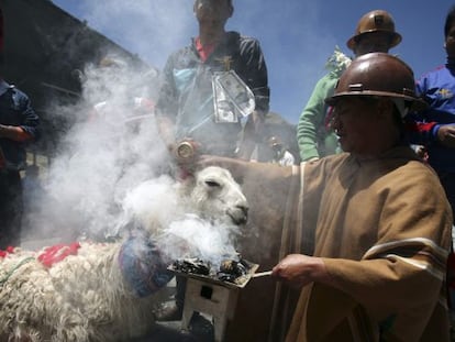 Un minero sujeta a una llama durante un ritual carnavalesco en Oruro.