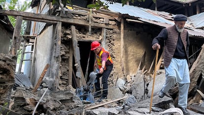 Un hombre y un rescatista en una casa destruida por un ataque en el pueblo de Salamabad, en la frontera entre India y Pakistán, e este sábado.