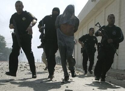 Un preso herido es detenido por la policía por participar en un motín en la cárcel de La Mesa, en Tijuana.