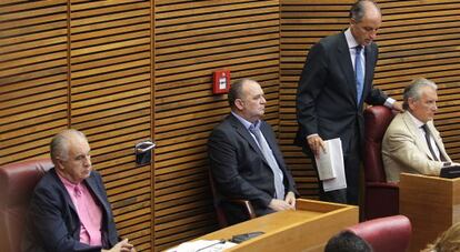 El expresidente Francisco Camps entra en el hemiciclo, con Rafael Blasco (izquierda) en su escaño de diputado no adscrito.