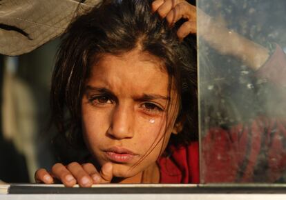 Una niña siria recién desplazada por la operación militar turca en el noreste de Siria, llora mientras se sienta en un autobús a su llegada al campamento de Bardarash, al norte de Mosul (Irak).