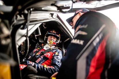 Carlos Sainz habla con Stéphane Peterhansel, su compañero en el equipo X-Raid Mini JCW Team, en una etapa del Rally Dakar en Arabia Saudí, en enero de 2020.