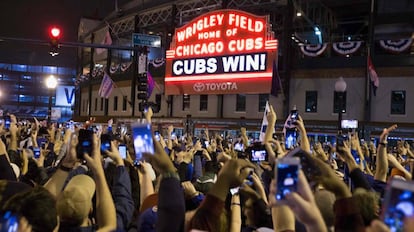 Aficionados de los Cubs festejan el triunfo a las afueras del Wrigley Field.