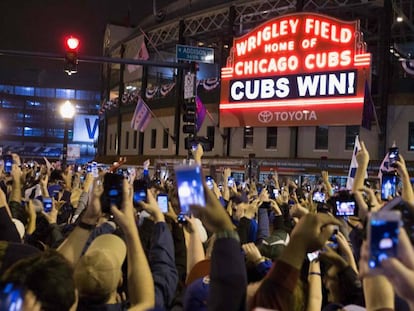 Aficionados de los Cubs festejan el triunfo a las afueras del Wrigley Field.