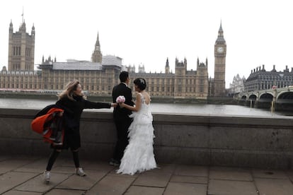 Una pareja posa para sus fotos de boda en el puente de Westminster en Londres, después de que el puente reabriera al tráfico tras el ataque terrorista del 22 de marzo de 2017.