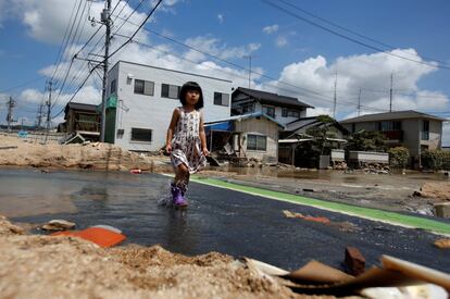 Una niña camina por un área afectada por las inundaciones en la ciudad de Mabi, Kurashiki (Japón).