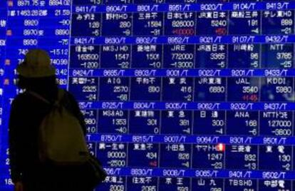 Una mujer se detiene ante una pantalla con los índices bursátiles en el centro de Tokio, Japón. La Bolsa de Tokio abrió con una subida de 47,45 puntos, el 0,52%. EFE/Archivo