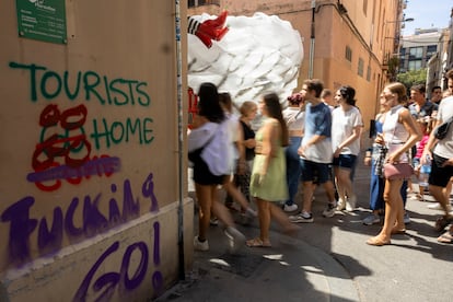 Pintada contra los turistas en la Plaza Raspall de Barcelona, en una fotografía tomada durante las fiestas de Gràcia.