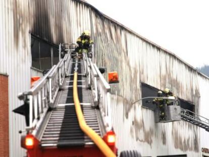 Los bomberos extinguen el fuego de la carpintería Zuhaitz, donde se encontraba atado el presunto asesino.