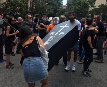 Dos manifestantes cargan un ataúd con la leyenda 'RIP Cultura'.