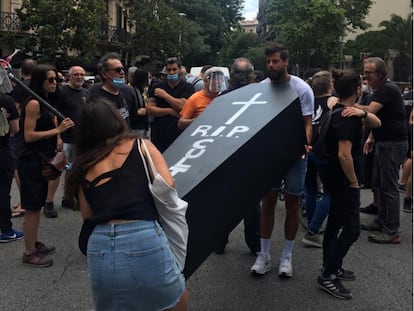 Dos manifestantes cargan un ataúd con la leyenda 'RIP Cultura'.