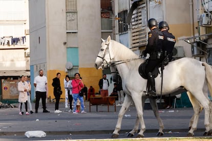 Los vecinos de las Tres Mil Viviendas observan la redada de la Policía Nacional que ha vuelto a desplegarse este viernes en esta barriada sevillana.