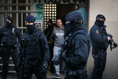 Los agentes de los Mossos d’Esquadra detienen a una persona durante el registro de una vivienda en la calle Arc de Sant Cristòfol (Barcelona), el 15 de enero de 2019, en el marco de una operación antiterrorista contra el terrorismo yihadista con vinculaciones con la delincuencia común.