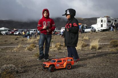Dos niños juegan con una réplica del auto de Robby Gordon mientras esperan ver el paso de los vehículos durante la séptima etapa del Dakar disputada en la localidad argentina de Salta.