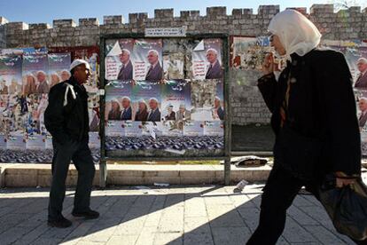 Dos palestinos pasan ante carteles de propaganda electoral en la ciudad vieja de Jerusalén.