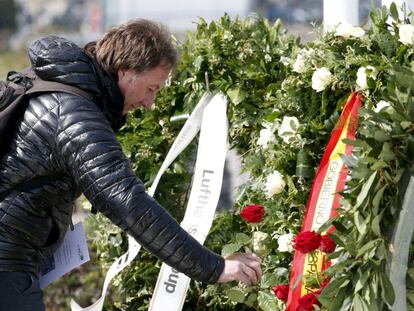 Un home diposita una flor en l'homenatge per les víctimes de Germanwings.
