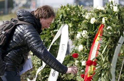 Un home diposita una flor en l'homenatge per les víctimes de Germanwings.
