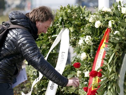 Un home diposita una flor en l'homenatge per les víctimes de Germanwings.