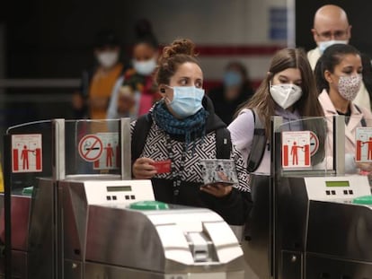 Usuarios de metro de Madrid cruzan los tornos.