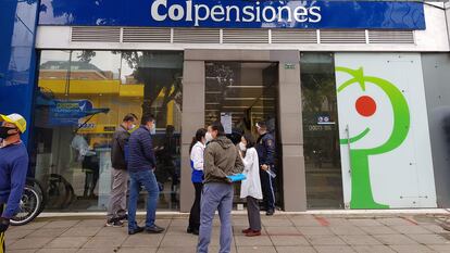 Personas esperan afuera de una sucursal de Colpensiones en Bogotá (Colombia).