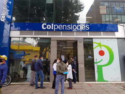 Personas esperan afuera de una sucursal de Colpensiones en Bogotá (Colombia).