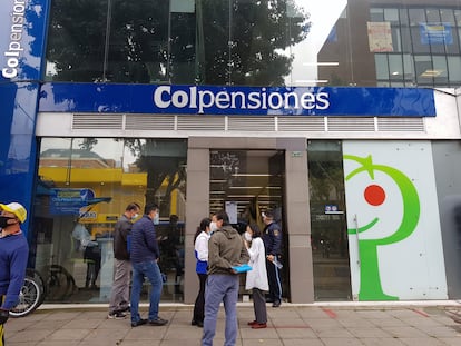 Un grupo de personas frente a una oficina de Colpensiones en Bogotá.