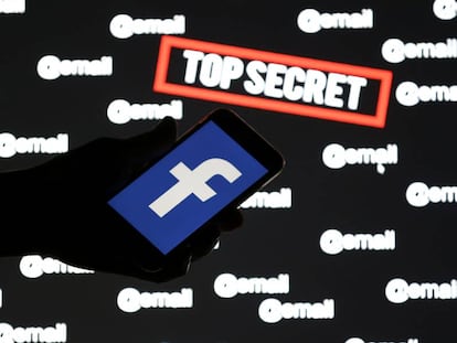 Pessoa segura um celular com o logo do Facebook sobre uma tela com as palavras 'top secret' e '@email'.