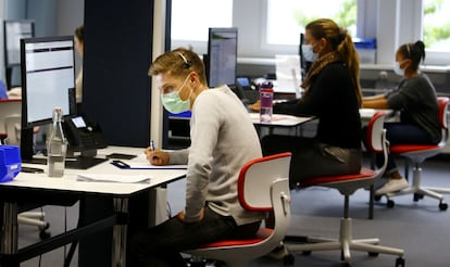 Varios trabajadores de un centro de atención al cliente hablan por teléfono.ARND WIEGMANN / REUTERS