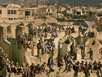 Decenas de hombres escuchan el discurso de Muhammad Karim Khalil, que luchó contra los talibanes en el norte de Afganistán, el 27 de diciembre de 2001 cerca de Kabul.